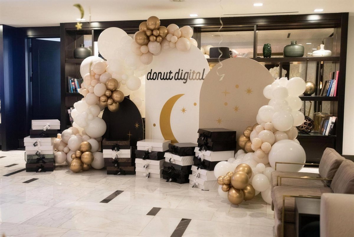 Branded balloon backdrop with gift boxes in a corporate lobby