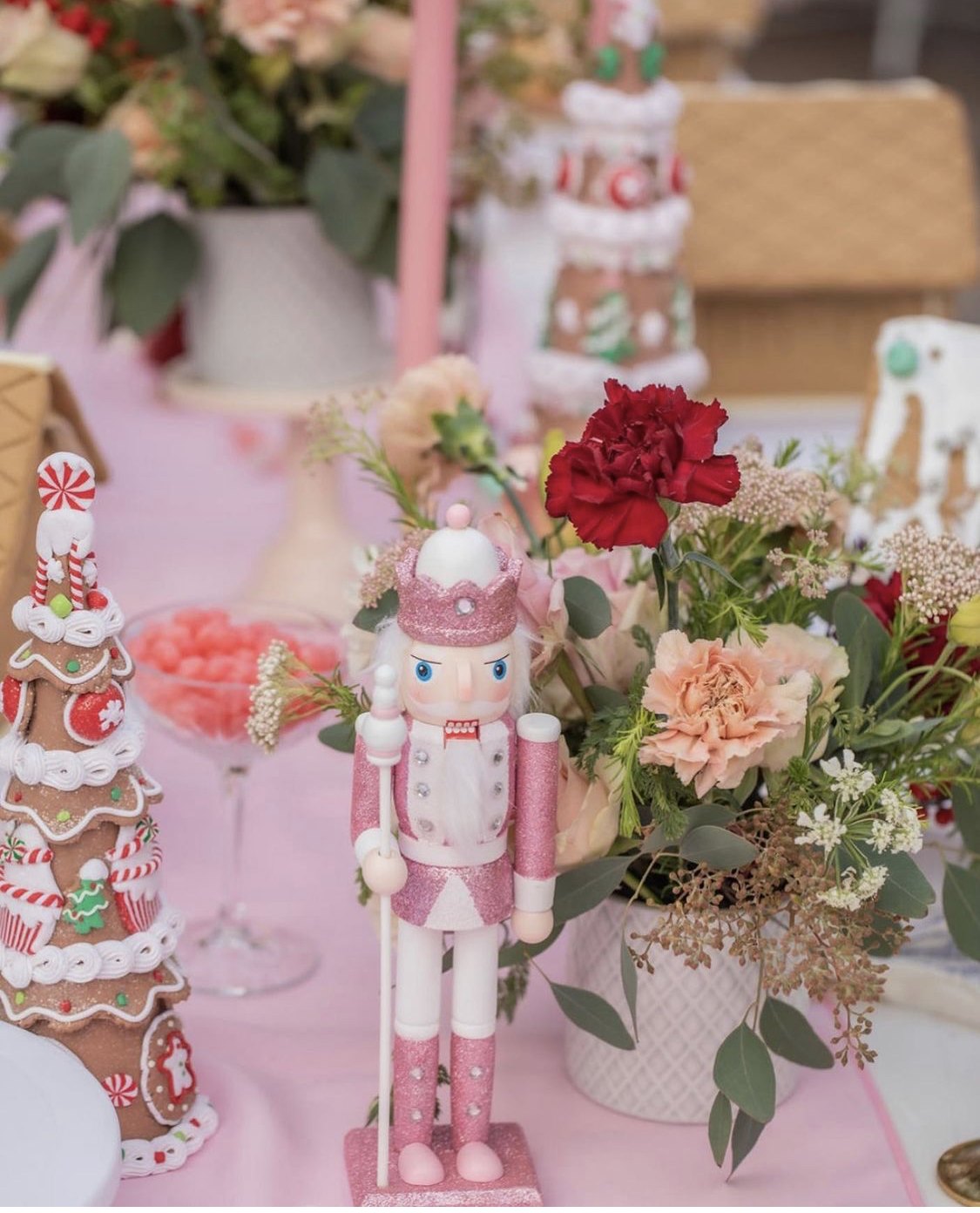 Pink glitter nutcracker beside pink and red florals