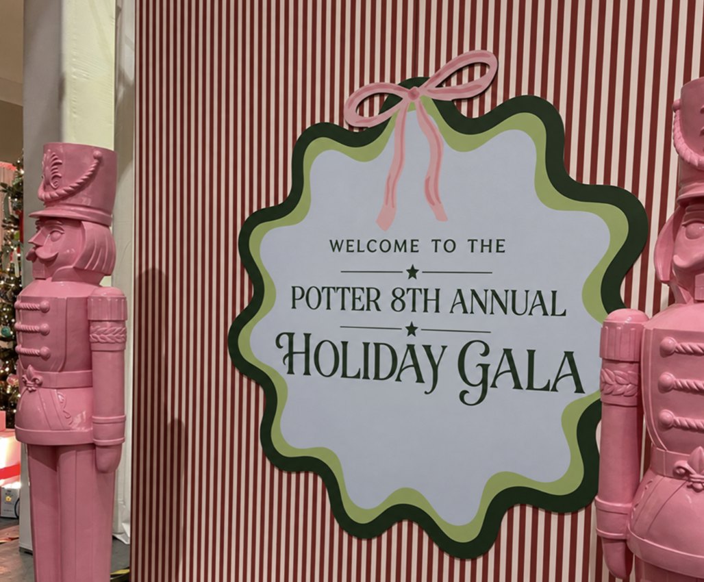 Custom scalloped welcome sign with a pink bow on a red-and-white striped wall between pink nutcrackers