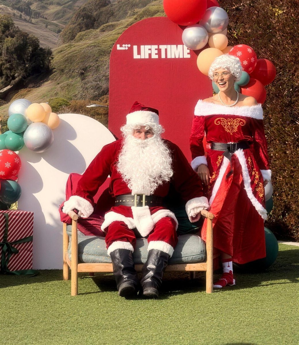 Santa and Mrs. Claus on a styled set with balloon garland